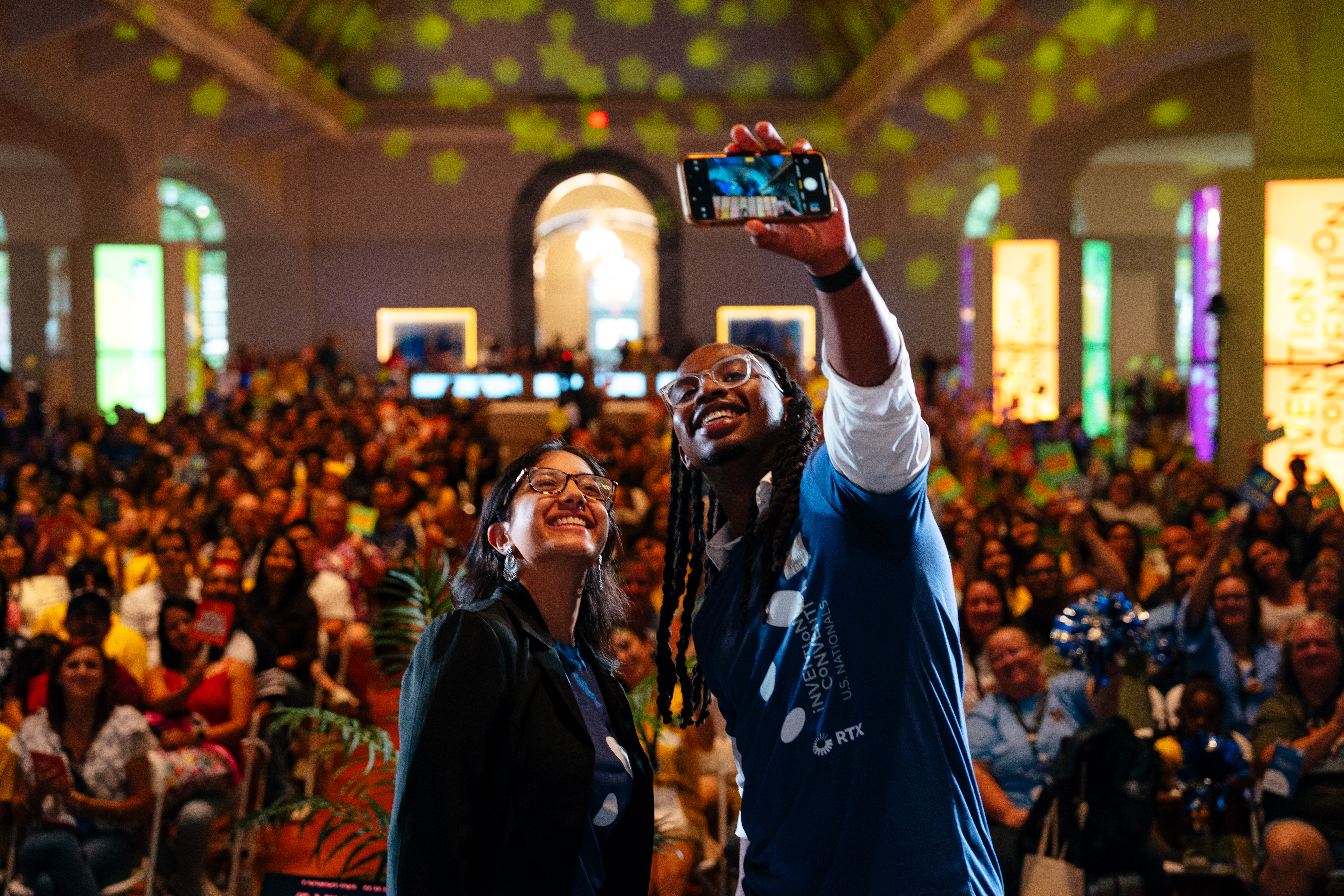nh_20260605_2285 Two people stand in front of a crowd taking a selfie