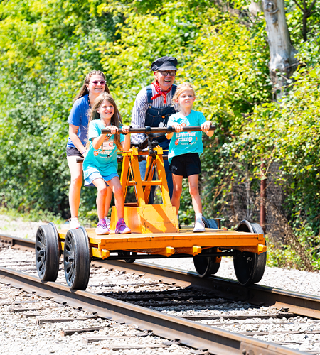 Students in blue shirts on an orange rail car